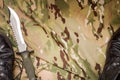 Combat knife and shoes on military camouflage fabric background Royalty Free Stock Photo