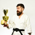 Combat master celebrates victory in competition. Man with beard in kimono on white background