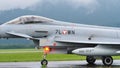 Combat military jet aircraft taxi on the runway in a raining day. Copy Space.