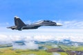 Combat tactical fighter flies in the sky above the clouds and the earth`s surface landscape of nature