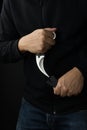 A man pulling out a karambit knife