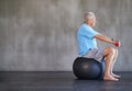 Combatting aging. an elderly man using weights while sitting on a swiss ball.