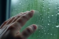 Combatting moisture, Hand removes window condensation in a humid home