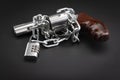 Combination key locked with metal chain and revolver hand gun on a black background , Gun security and safety concept Royalty Free Stock Photo