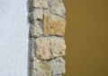 A combination of modern structural plaster and preservation of parts of the old sandstone stone wall. stone strip of yellow stones Royalty Free Stock Photo