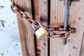Combination padlock and rusty iron chain securing the door of outdoor bathroom Royalty Free Stock Photo