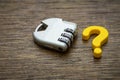 A combination padlock sits beside a bright yellow question mark, symbolizing a complex problem or secret that requires the right Royalty Free Stock Photo