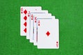 Combination of playing cards of diamonds suit on green baize Royalty Free Stock Photo