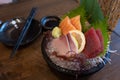 Combination sashimi set consisting of pickled salmon, tuna and hamachi on a dark bowl Royalty Free Stock Photo