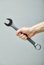 combination wrench in male hands close-up, on gray background. Copy space Royalty Free Stock Photo