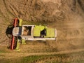 Combine harvester - Aerial view of modern combine harvester at the harvesting the wheat on the golden wheat field in the summer Royalty Free Stock Photo