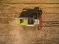 Combine harvester - Aerial view of modern combine harvester at the harvesting the wheat on the golden wheat field in the summer Royalty Free Stock Photo