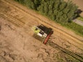 Combine harvester - Aerial view of modern combine harvester at the harvesting the wheat on the golden wheat field in the summer Royalty Free Stock Photo