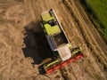 Combine harvester - Aerial view of modern combine harvester at the harvesting the wheat on the golden wheat field in the summer Royalty Free Stock Photo