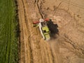 Combine harvester - Aerial view of modern combine harvester at the harvesting the wheat on the golden wheat field in the summer Royalty Free Stock Photo