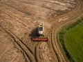 Combine harvester - Aerial view of modern combine harvester at the harvesting the wheat on the golden wheat field in the summer Royalty Free Stock Photo