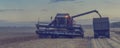 Combine harvester agricultural machine harvesting golden ripe wheat fields. Toned