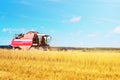 Combine harvester agriculture machine harvesting ripe wheat in farm field Royalty Free Stock Photo