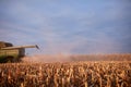 Combine harvester harvesting maize at sundown
