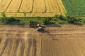 Combine harvester harvesting wheat, aerial view . Wheat field at sunset. Harvester working on wheat field