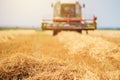 Combine harvester machine harvesting ripe wheat crops Royalty Free Stock Photo