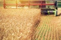 Combine harvester machine harvesting ripe wheat crops Royalty Free Stock Photo