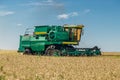 Combine harvester machine harvesting wheat in the field at sunny day Royalty Free Stock Photo