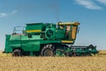 Combine harvester machine harvesting wheat in the field at sunny day Royalty Free Stock Photo