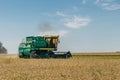 Combine harvester machine harvesting wheat in the field at sunny day Royalty Free Stock Photo