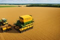 The combine harvester pours corn grain into the truck.