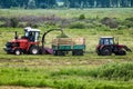 Combine harvester and tractor remove grass