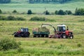 Combine harvester and tractor remove grass