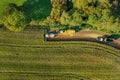 Combine harvester and tractors are harvesting corn maize. Aerial photography from drone above harvester working in the field. Royalty Free Stock Photo