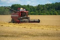 The combine harvester is working in the field. Agro-industrial complex, grain harvest season. Harvesting and harvesting of wheat, Royalty Free Stock Photo