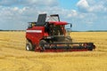 The combine harvester is working in the field. Agro-industrial complex, grain harvest season. Harvesting and harvesting of wheat, Royalty Free Stock Photo