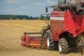 The combine harvester is working in the field. Agro-industrial complex, grain harvest season. Harvesting and harvesting of wheat, Royalty Free Stock Photo