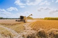 Combine harvester working on large oat field on a sunny day Royalty Free Stock Photo