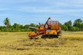 Combine harvester Working on rice field. Harvesting is the process of gathering a ripe crop from the fields Royalty Free Stock Photo