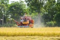 Combine harvester Working on rice field. Harvesting is the process of gathering a ripe crop from the fields Royalty Free Stock Photo