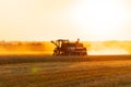 Combine harvester working on wheat field. Combine harvester working on golden crop field at sunset. Harvesting concept Royalty Free Stock Photo