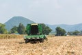 Combine harvesters are working in corn fields. Harvesting of corn field with combine in early autumn. Royalty Free Stock Photo