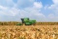 Combine harvesters are working in corn fields. Harvesting of corn field with combine in early autumn.