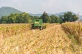 Combine harvesters are working in corn fields. Harvesting of corn field with combine in early autumn. Royalty Free Stock Photo