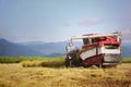 A combine is harvesting ripe rice and grains in the fall rice fields. Royalty Free Stock Photo