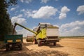 Combine harvesting wheat and unloading grains into tractor trailer Royalty Free Stock Photo