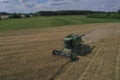 The combine harvests ripe wheat in the grain field. Agriculture. Aerial view. From above.