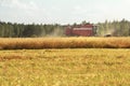 Combine machine with header or cutting blade working in grain summer field Royalty Free Stock Photo