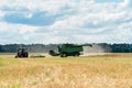 Combine wheat crops harvesting in a summer field