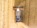 Combined harvester-thresher with tanker is at work on wheat field, top view Royalty Free Stock Photo