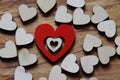 Combined heart made of wood painted red and wooden hearts of natural color on wooden surface. Symbolic concept love, relationship
